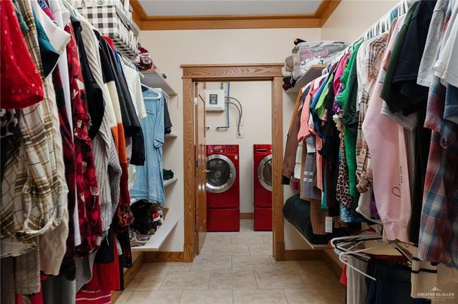 Walk in closet featuring light tile patterned flooring and independent washer and dryer | Image 17