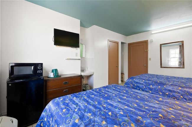 Bedroom with a sink and fridge | Image 14