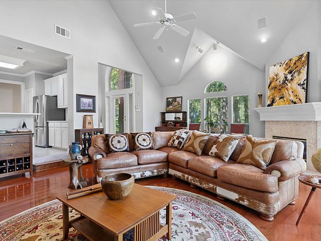 Living area featuring wood finished floors, high vaulted ceiling, a ceiling fan, recessed lighting, and a fireplace | Image 8