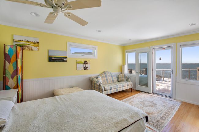 Bedroom with light wood finished floors, a wainscoted wall, ceiling fan, access to exterior, and crown molding | Image 14