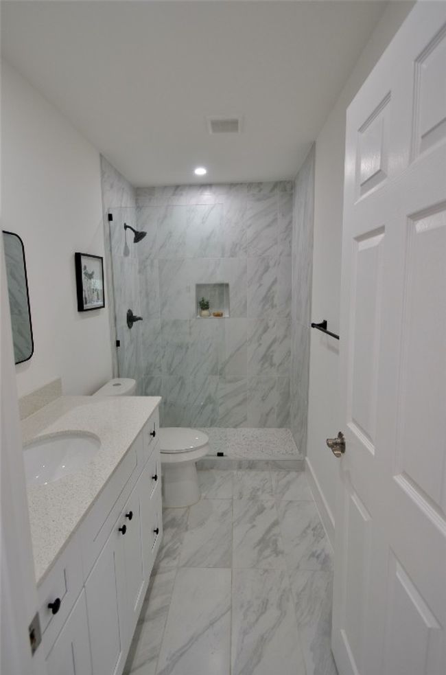 Full bath with vanity, walk in shower, and marble finish floors | Image 6