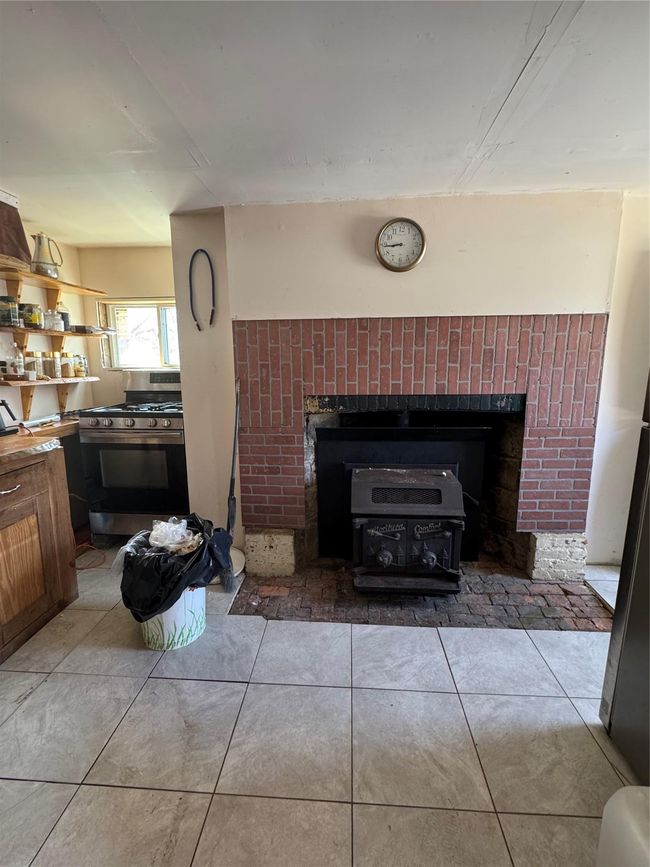Room details featuring stove and a fireplace | Image 12