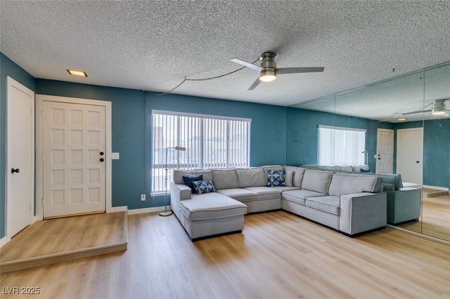 Living room with ceiling fan, wood finished floors, and a textured ceiling | Image 7