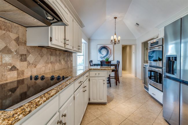 Kitchen with range hood, tasteful backsplash, visible vents, appliances with stainless steel finishes, and a peninsula | Image 17