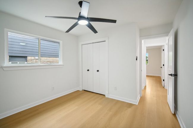 Unfurnished bedroom with multiple windows, baseboards, light wood-type flooring, and a closet | Image 19