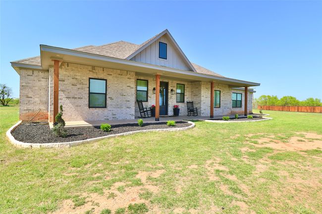 View of front of property featuring fence, a front lawn, roof with shingles, a porch, and brick siding | Image 4
