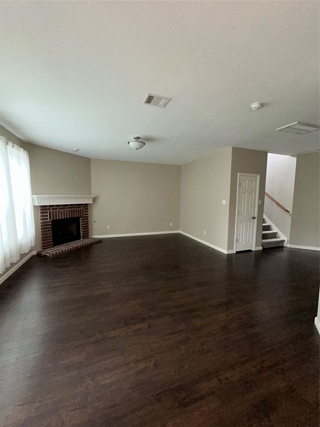 Unfurnished living room with dark wood-style flooring, stairs, and baseboards | Image 21