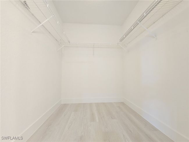 Walk in closet with light wood-style floors | Image 30