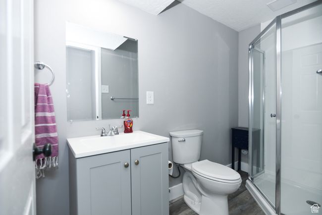 Full bathroom featuring toilet, a shower stall, wood finished floors, and vanity | Image 31