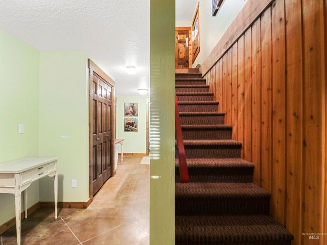 Stairs featuring a textured ceiling and tile patterned floors | Image 35