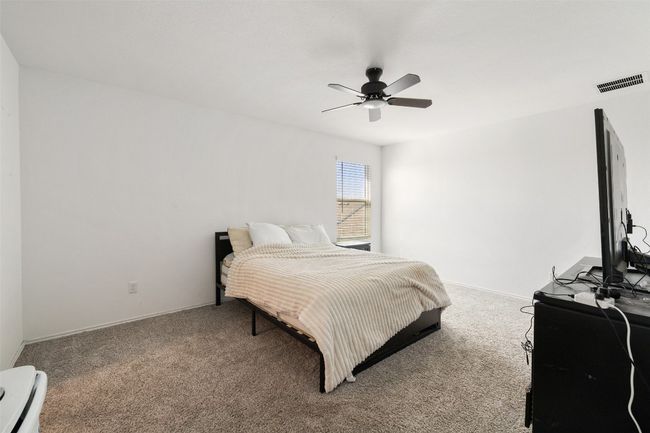 Bedroom with carpet flooring, ceiling fan, and baseboard heating | Image 18