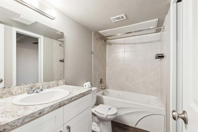 Full bath with vanity, washtub / shower combination, and a textured ceiling | Image 7