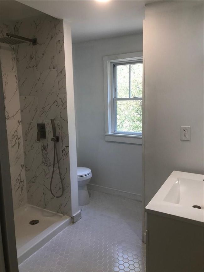Bathroom featuring tiled shower, vanity, toilet, and tile patterned flooring | Image 27