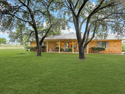 As you enter through the electric gate, you're greeted by the beauty of towering oak trees in the front yard and the promise of peaceful living. | Image 2