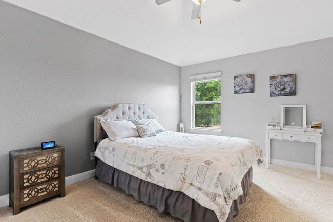 Carpeted bedroom featuring baseboards, lofted ceiling, and a ceiling fan | Image 26