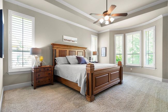 First floor primary suite with sitting area with views of the greenbelt | Image 17
