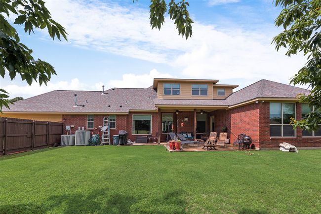 Back of house featuring ceiling fan, brick siding, a patio area, and a fenced backyard | Image 39