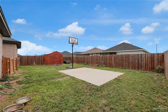 Fenced backyard with a storage unit and a patio | Image 18