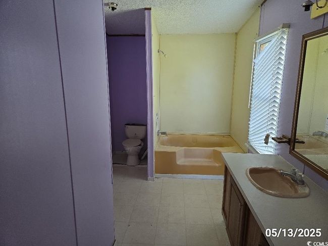 Full bath with toilet, a bath, vanity, a textured ceiling, and tile patterned floors | Image 22