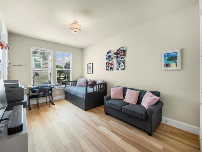 Bedroom featuring wood finished floors, baseboards, and an office area | Image 16