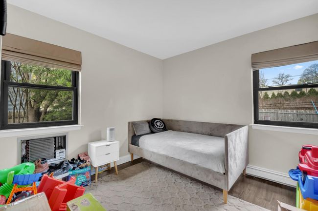 Bedroom with baseboards, baseboard heating, and wood finished floors | Image 18