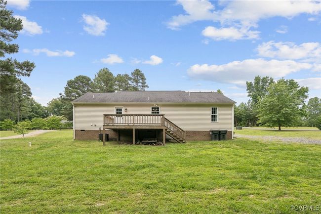 Rear view of property with a wooden deck, crawl space, a yard, and stairs | Image 32