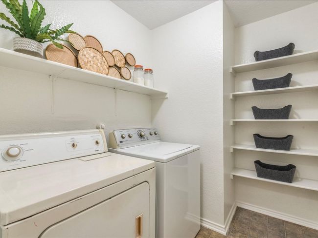 The in home laundry room comes with charming built-in shelving for your storage needs plus a shelf behind the washer and dryer. | Image 24