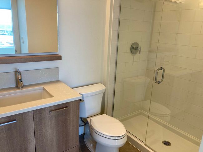 Bathroom with a shower stall, toilet, and vanity | Image 25