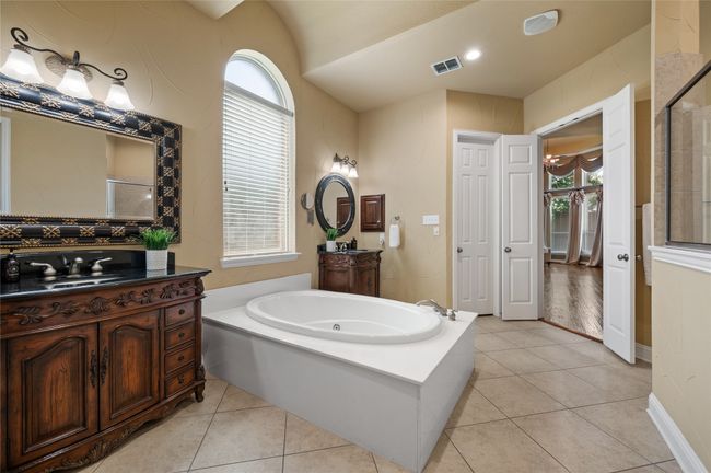 Full bathroom featuring a bath, vanity, plenty of natural light, and lofted ceiling | Image 24