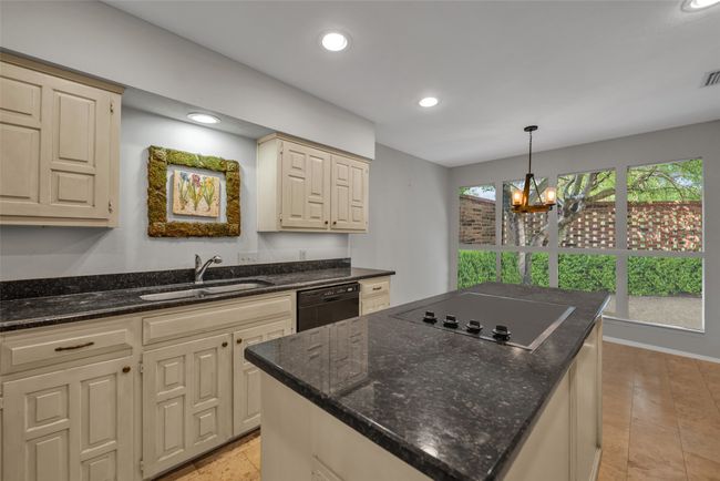 Kitchen has tons of storage, breakfast room with custom lighting, and front patio views. | Image 15