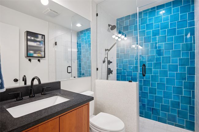 Third bathroom offers similar ocean blue tones with full updates including vanity, fixtures, shower tile, and more. | Image 19
