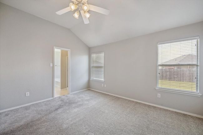 Carpeted spare room with plenty of natural light, a ceiling fan, baseboards, and vaulted ceiling | Image 13