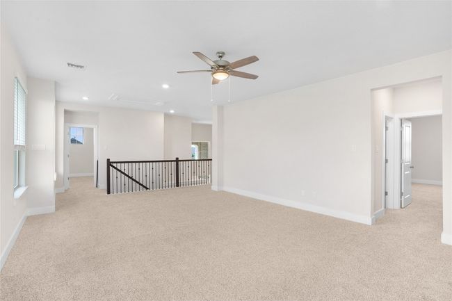 Empty room featuring light carpet, ceiling fan, recessed lighting, baseboards, and attic access | Image 17