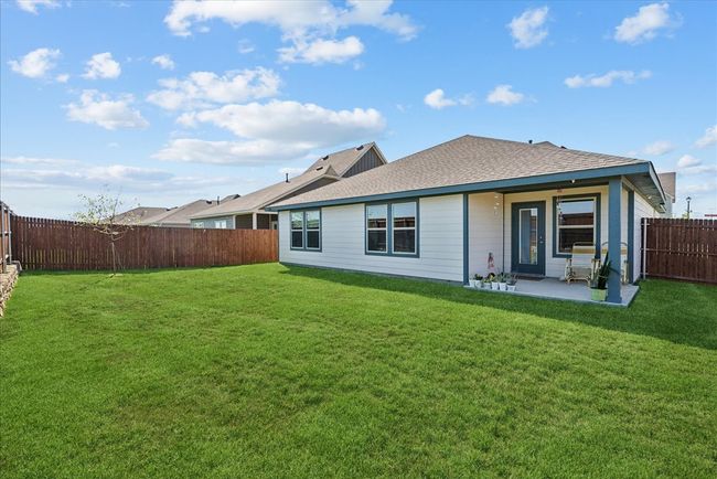 Rear view of house featuring a fenced backyard, a patio, and roof with shingles | Image 12