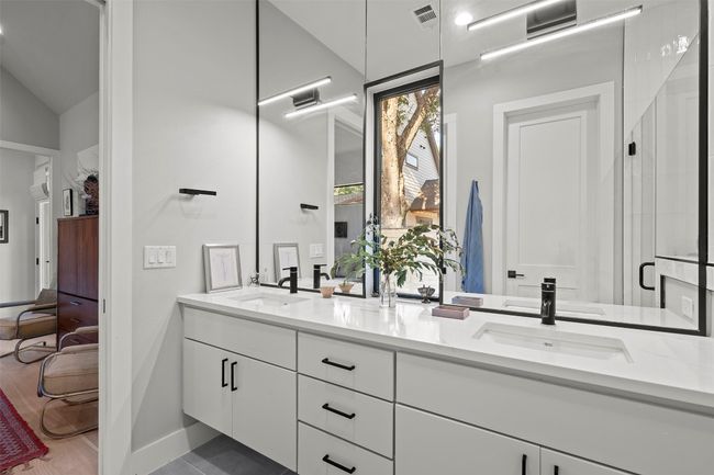 Ensuite bathroom featuring double vanity, a stall shower, vaulted ceiling, and a wall mounted air conditioner | Image 27