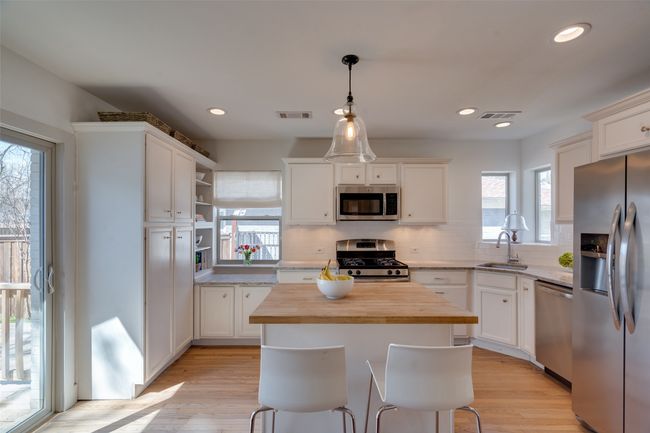 Kitchen featuring open shelves, butcher block counters, light wood-type flooring, appliances with stainless steel finishes, and a sink | Image 8