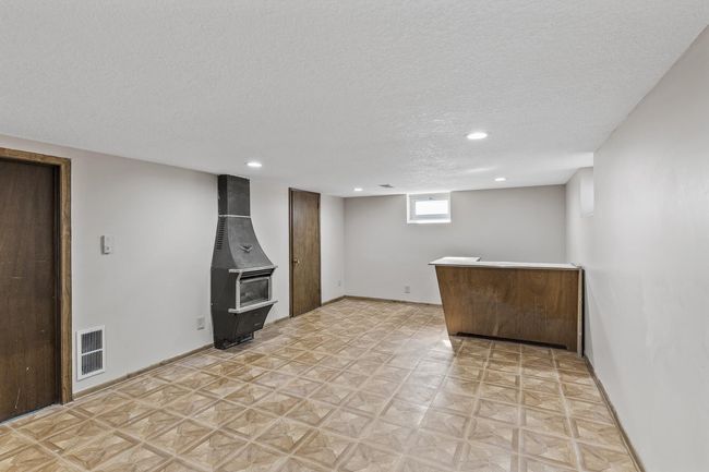 Additional view of the lower level family room with an electric fireplace and bar. | Image 22