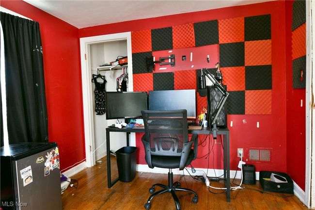 Office with an accent wall, wood finished floors, visible vents, baseboards, and wallpapered walls | Image 38