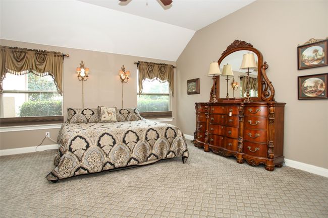 Bedroom featuring carpet flooring, lofted ceiling, baseboards, and a ceiling fan | Image 19