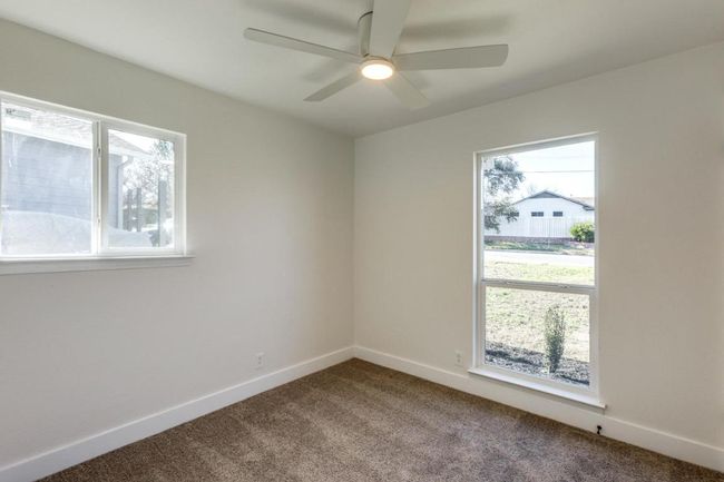 Carpeted empty room with ceiling fan and baseboards | Image 18