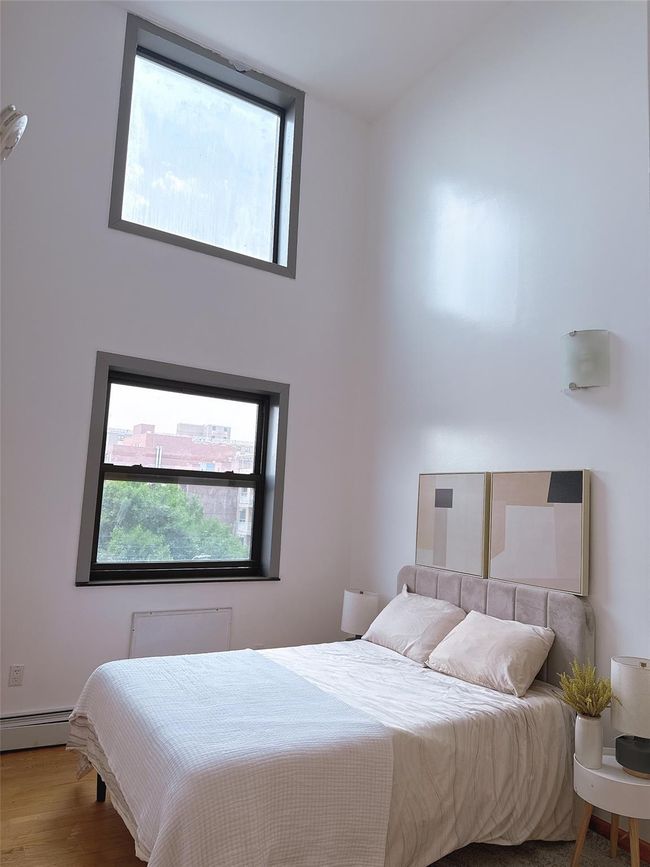 Bedroom with a baseboard radiator and wood finished floors | Image 9