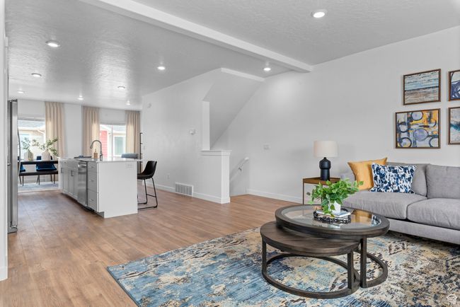Living area with light wood-type flooring, a textured ceiling, and recessed lighting | Image 6