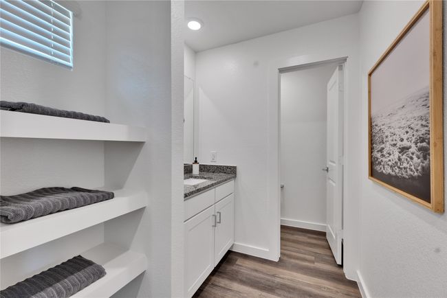 Bathroom with baseboards, wood finished floors, and vanity | Image 28