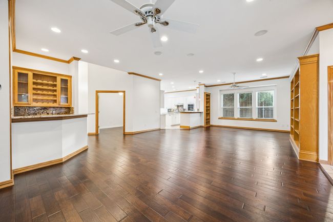 Large living- game room combo with a ceiling fan, crown molding, baseboards, dark wood- flooring, and recessed lighting | Image 8