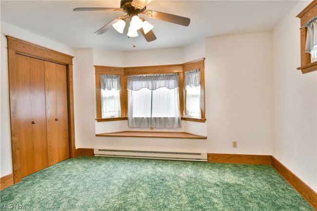 Unfurnished bedroom featuring ceiling fan, a baseboard heating unit, a closet, and carpet floors | Image 16