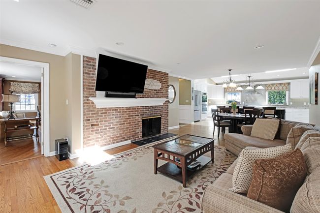 Living area featuring light wood finished floors, crown molding, and a chandelier | Image 14