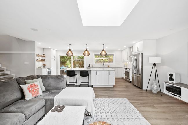 Living room featuring a skylight, light wood finished floors, stairs, and recessed lighting | Image 19