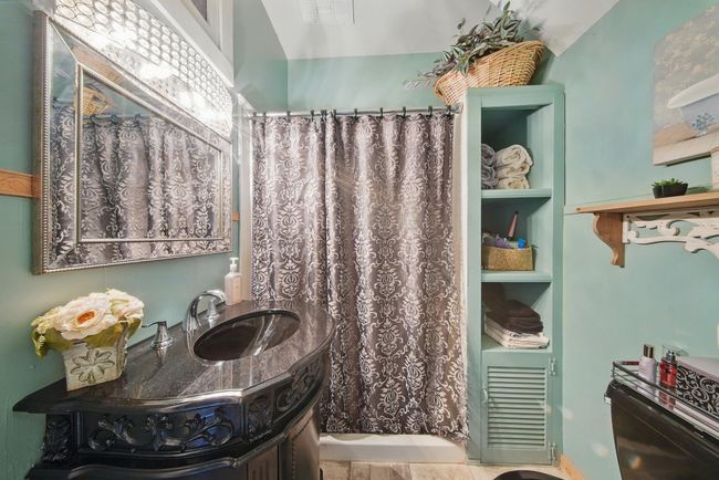Bathroom featuring vanity and curtained shower | Image 24