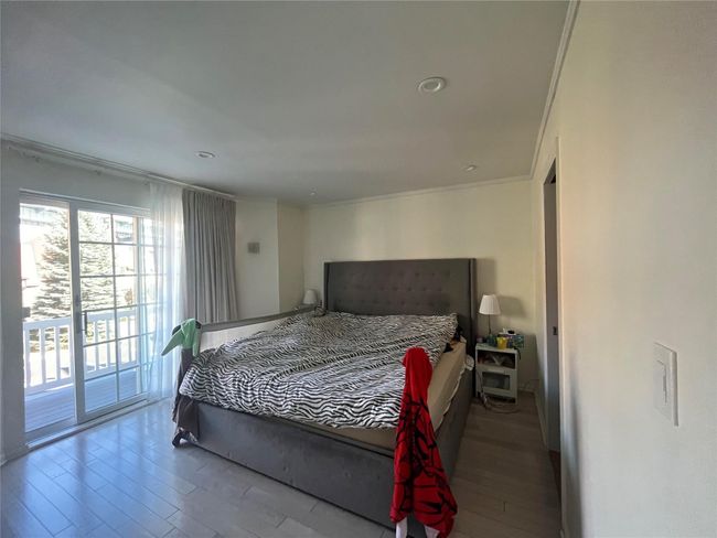 Bedroom with wood finished floors, ornamental molding, and access to exterior | Image 7