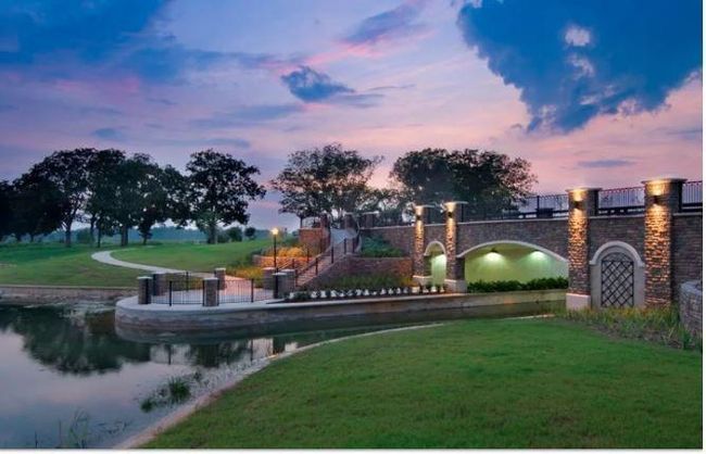 As the sun sets, the tranquil beauty of the Riverstone community comes to life. This twilight view captures the bridge, walking trails, and lake, providing a serene and calming environment for evening walks or quiet reflection. | Image 10